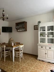 een eetkamer met een tafel en een witte kast bij 81Passi in Casale Marittimo