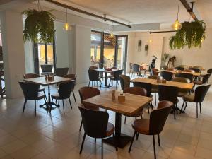 - un restaurant avec des tables et des chaises dans une salle dans l'établissement Ureki Hotel Olympia Family Room, à Ureki