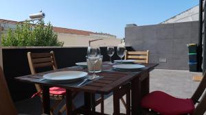 a wooden table with wine glasses on a balcony at SottoMayor Best Residence in Figueira da Foz