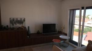 sala de estar con TV de pantalla plana y mesa en SottoMayor Best Residence en Figueira da Foz
