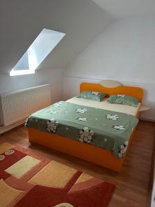 Cucuceni的住宿－Cabana Vladimir，一间卧室配有一张带绿毯的橙色床