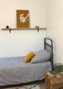 1 dormitorio con cama con almohada amarilla y estante en Appartement central maison Marceau, en Rivesaltes