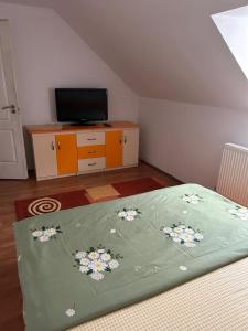 a bedroom with a bed and a tv on a dresser at Cabana Vladimir in Cucuceni