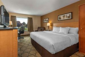 um quarto de hotel com uma cama grande e uma televisão de ecrã plano em Comfort Inn Drummondville em Drummondville