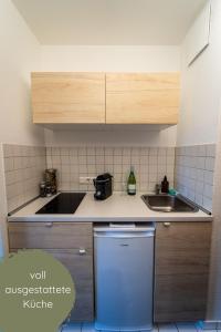 a small kitchen with a sink and a dishwasher at Businessapartment Zentral & Modern nahe Hauptbahnhof, schnelles WLAN in Essen