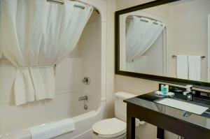 a bathroom with a toilet and a sink and a mirror at Comfort Inn Drummondville in Drummondville
