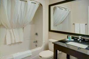 bagno con servizi igienici, lavandino e specchio di Comfort Inn Drummondville a Drummondville