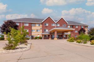 a large red brick building with a parking lot at MainStay Suites Dubuque at Hwy 20 in Dubuque