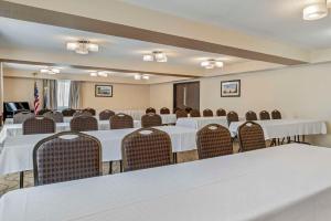 einen Konferenzraum mit weißen Tischen und Stühlen in der Unterkunft Comfort Inn in Manistique