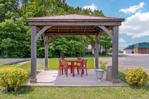 a wooden gazebo with red chairs and a table at Quality Inn in Saint Ignace
