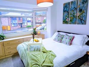 Schlafzimmer mit einem Bett und einem Fenster in der Unterkunft 4Bedroom house Manchester-Centre/Hospital/Motorways/Uni in Manchester