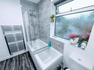 ein Bad mit einer Dusche, einem Waschbecken und einem Fenster in der Unterkunft 4Bedroom house Manchester-Centre/Hospital/Motorways/Uni in Manchester