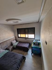 イモーザル・ドゥ・カンダルにあるChalet villa QUE POUR LES FAMILLESのベッドルーム1室(ベッド2台、窓、スーツケース付)