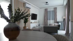 uma sala de estar com um vaso de flores sobre uma mesa em Apartments L-A-M em Podstrana