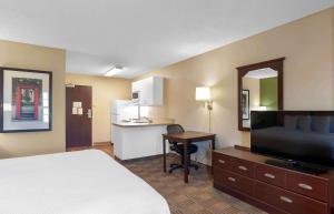 a hotel room with a bed and a desk and a kitchen at Extended Stay America Suites - Mobile - Spring Hill in Mobile
