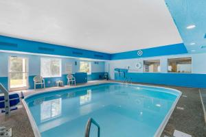 - une grande piscine dans une pièce aux murs bleus dans l'établissement Quality Suites La Grange, à La Grange