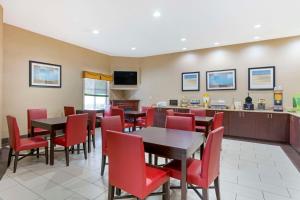un restaurant avec des chaises et des tables rouges ainsi qu'un bar dans l'établissement Quality Suites La Grange, à La Grange