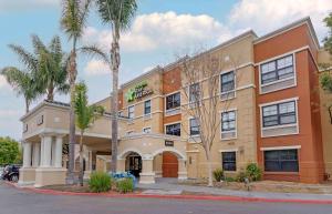 a hotel building with palm trees in front of it at Extended Stay America Suites - Fremont - Newark in Fremont