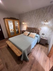 1 dormitorio con 1 cama grande y espejo en El Rincón del Val, 