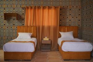 two beds sitting next to each other in a room at Magic Bedouin Star in Wadi Rum