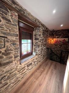 a room with a stone wall and a window at El Rincón del Val 