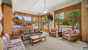 uma sala de estar com um sofá, cadeiras e janelas em Clarion Hotel & Suites Fairbanks near Ft Wainwright em Fairbanks