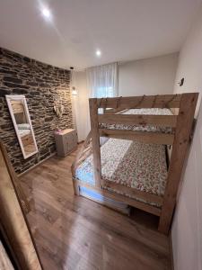 1 dormitorio con 2 literas y pared de piedra en El Rincón del Val, 