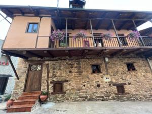 a building with a balcony with flowers on it at El Rincón del Val in Priaranza del Bierzo