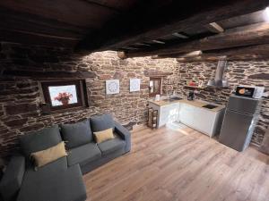 a living room with a couch and a kitchen at El Rincón del Val in Priaranza del Bierzo +29 photos