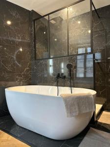 La salle de bains est pourvue d'une grande baignoire blanche. dans l'établissement Gîte Liberta - Equipé d'une balneo entre Dinan et St Malo, à Saint-Pierre-de-Plesguen