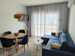 a living room with a blue couch and a table at White Apartment in Kumbor