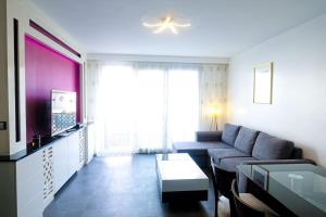 a living room with a couch and a tv at Bel Appartement proche Paris 16eme in Boulogne-Billancourt