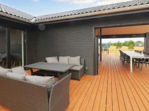 a wooden deck with a table and chairs and a patio at Luxury Retreat in Marielyst - By Traum Ferienwohnungen in Marielyst