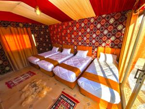 een slaapkamer met 2 bedden en een muur met patronen bij Magic Bedouin Star in Wadi Rum