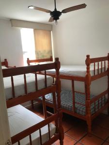 a room with three bunk beds and a ceiling fan at Apartamento Praia do Forte - Cabo Frio in Cabo Frio