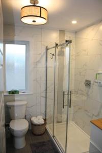 a bathroom with a glass shower and a toilet at Luxueux chalet sur la plage - Baie des Chaleurs in Caraquet