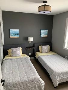 1 dormitorio con 2 camas en una habitación en Luxueux chalet sur la plage - Baie des Chaleurs, en Caraquet