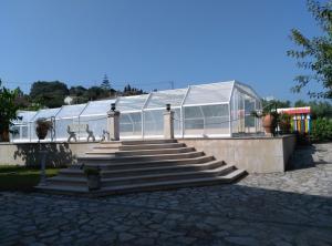 una casa de cristal con escaleras delante en Alojamento Local Céu-Azul, en Porto de Mós