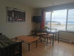 a living room with a table and chairs and a couch at Qualicum Bay Resort in Bowser