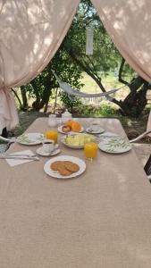einen Tisch mit Teller mit Lebensmitteln und Gläsern Orangensaft in der Unterkunft Las Golondrinas de Henche 