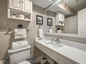 a bathroom with a sink and a toilet and a mirror at Heart of Westport 1BR in Kansas City
