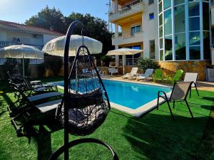 a swing in a yard next to a swimming pool at Kopernikus Apartments in Ulcinj