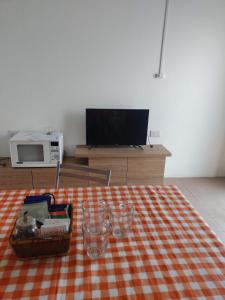 sala de estar con mesa con manta y TV en Lo de Bibi en Santa Rosa