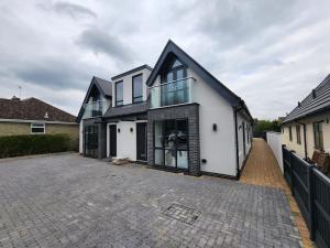 a white and black house with a driveway at Paradigm Court, Modern 3-Bedroom Flat 1, Oxford in Oxford