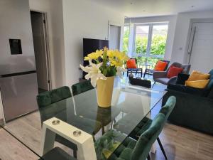 een woonkamer met een glazen tafel met bloemen erop bij Paradigm Court, Modern 3-Bedroom Flat 1, Oxford in Oxford