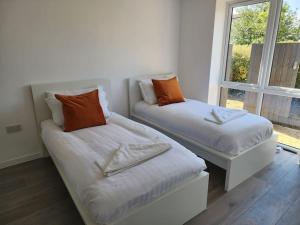 two beds sitting in a room with a window at Paradigm Court, Modern 3-Bedroom Flat 1, Oxford in Oxford