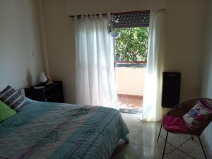 sypialnia z łóżkiem i oknem w obiekcie Buenos Aires Tango Apartment near Golf w mieście San Antonio de Padua