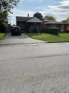 a house with a car parked on the side of a street at Windsor Airport Accommodation in Windsor