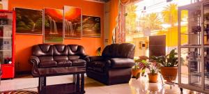 uma sala de estar com duas cadeiras de couro e uma mesa em Hotel El Super 8 em Cochabamba