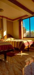 a bedroom with a bed and a large window at Hotel El Super 8 in Cochabamba